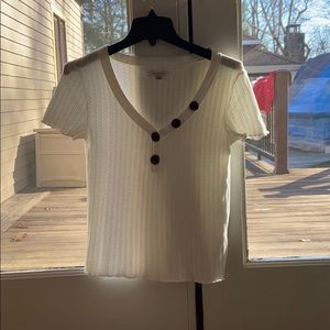 White tshirt w brown buttons.